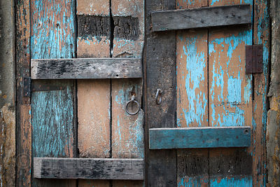 A weathered, blue-painted wooden door in Kolkata, India.